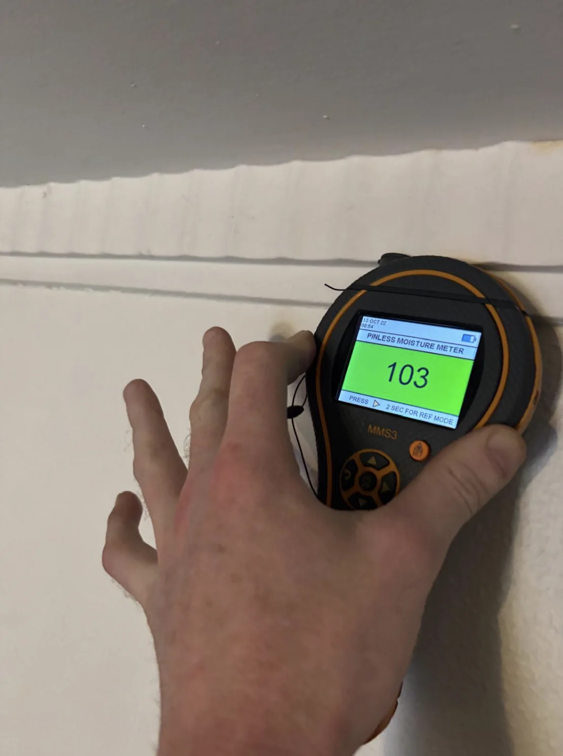 Digital moisture reading taken during an on-site assessment