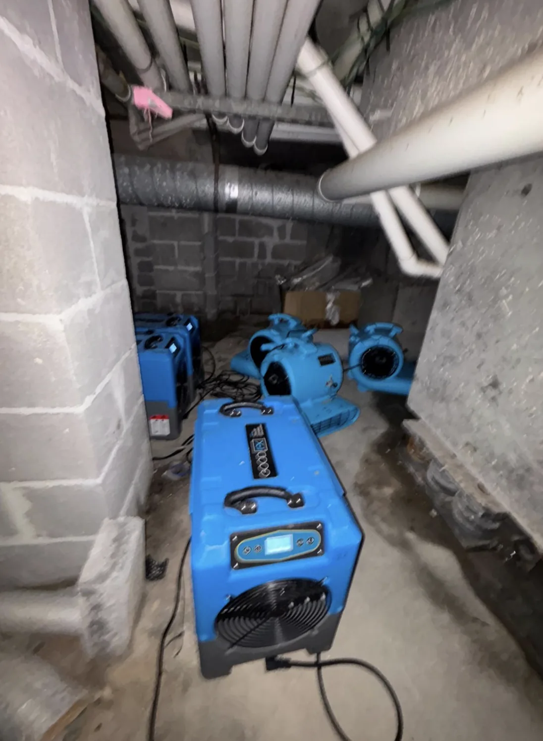 High-velocity air movers set up in a subfloor space