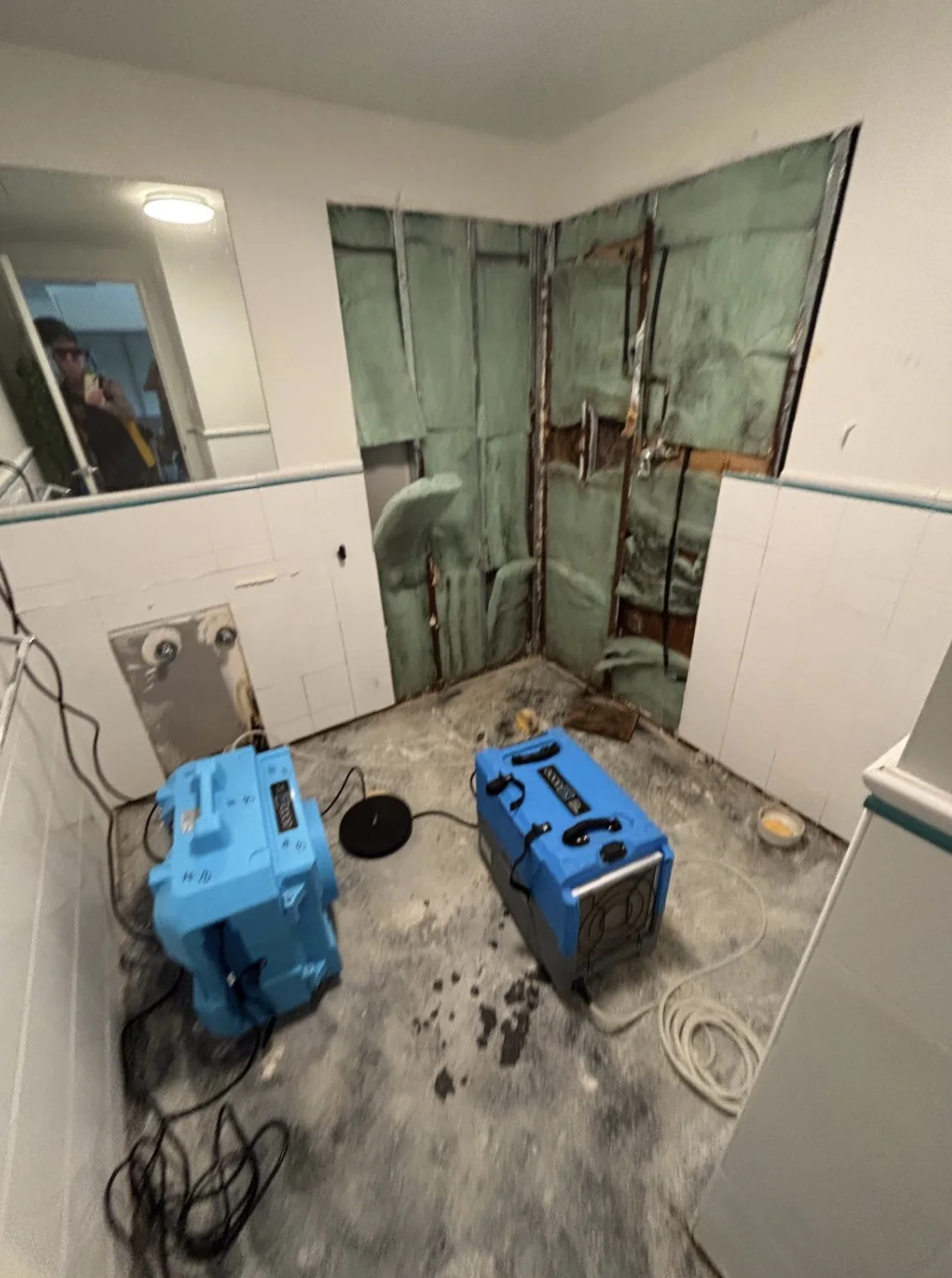 Air movers drying an opened wall cavity after water damage